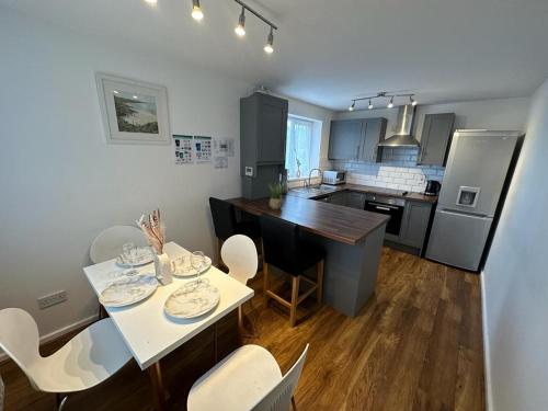 a kitchen with a table and chairs in a kitchen at 3 Bedroom House For Corporate Stays in Kettering in Kettering