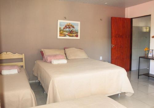 a bedroom with two beds and a table and a mirror at Pousada e Bistrô Estância Monte Horebe in Mulungu