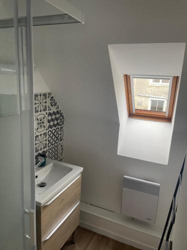 une salle de bain avec un lavabo et une fenêtre dans l'établissement Cocon douillet en bord de mer, à Grandcamp-Maisy
