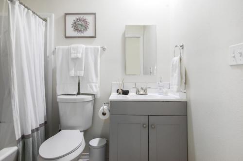 uma casa de banho branca com um WC e um lavatório em Magnolia on Lake Travis area em Austin