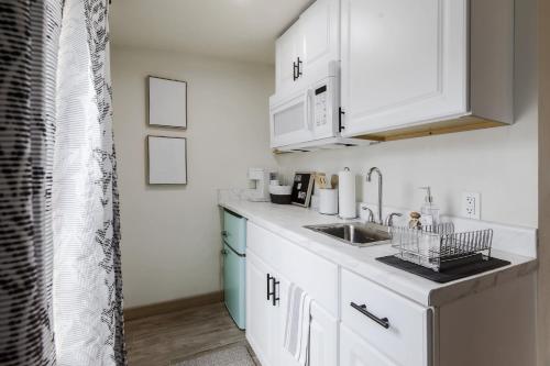 uma cozinha com armários brancos e um lavatório em Magnolia on Lake Travis area em Austin