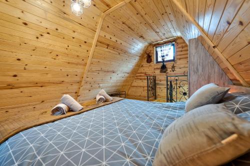 a bedroom with a bed in a wooden cabin at Vila Deniri in Zlatibor