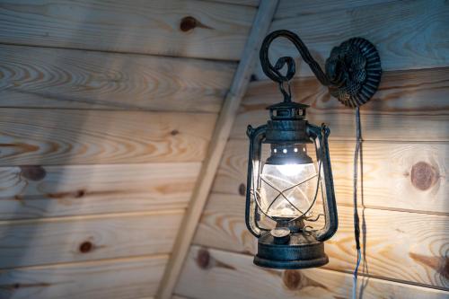 a lantern hanging on a wall with a wooden wall at Vila Deniri in Zlatibor