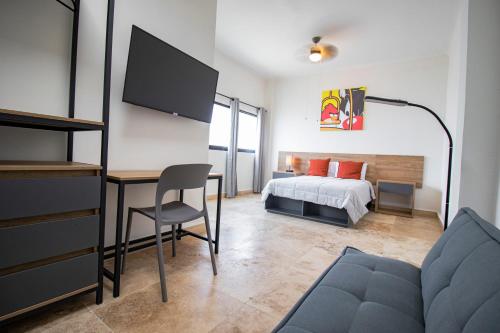 1 dormitorio con 1 cama y escritorio con TV en Hostal 170, en Orizaba