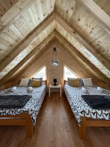 two beds in the attic of a log cabin at Brvnare MADERA Banja Ždrelo in Ždrelo
