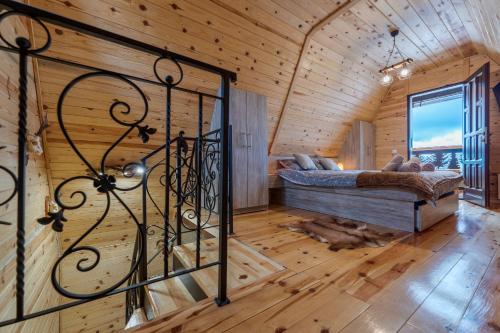 a bedroom in a log cabin with a bed and a window at Vila Deniri in Zlatibor