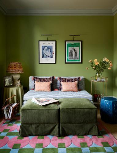 a bedroom with a bed and a green wall at Beaverbrook Town House in London