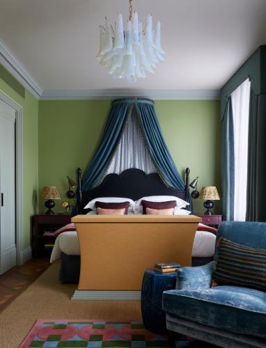 a bedroom with a large bed with a chandelier at Beaverbrook Town House in London