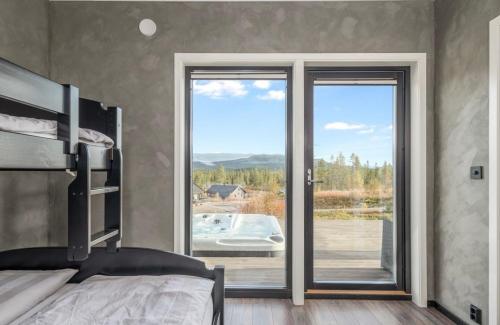 a bedroom with a bed and a large glass window at Hytte Trysil SPA in Trysil