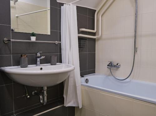 a bathroom with a sink and a bath tub at Strand Apartman in Fonyód