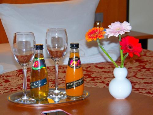 two bottles of beer and two glasses on a table at Hotel Amadeus ROYAL Berlin in Berlin