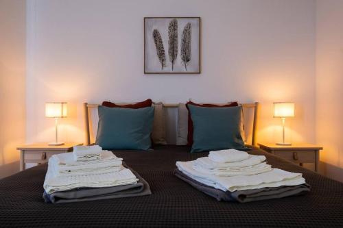 a bed with towels stacked on top of it at Vila Nova Suite Apt (historic PDL city center) in Ponta Delgada