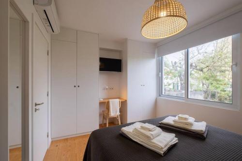 um quarto com uma cama com duas toalhas em Vila Nova Suite Apt (historic PDL city center) em Ponta Delgada
