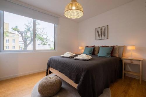 um quarto com uma cama e uma grande janela em Vila Nova Suite Apt (historic PDL city center) em Ponta Delgada