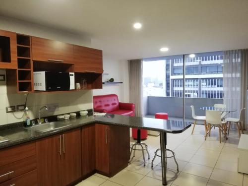 una cucina con bancone, tavolo e sedie di Apartamento Reforma Ciudad de Guatemala a Guatemala