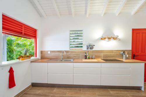 サン・フランソワにあるVilla Oasis St François 5 Étoilesの白いキャビネットと窓のあるキッチン