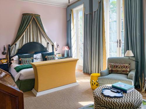 um quarto com uma cama grande e uma cadeira em Beaverbrook Town House em Londres