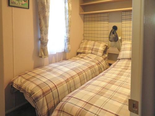 two beds sitting next to each other in a room at Windy Roost Lodge in Tydd Saint Giles