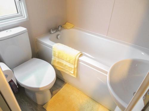 a bathroom with a white toilet and a sink at Windy Roost Lodge in Tydd Saint Giles