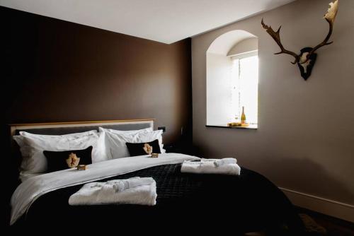 a bedroom with a large bed with towels on it at Luxury 4 Bed Dales Retreat Private Walled Garden All Ensuite Sleeps 8 SuperKing 1 Double 2 King 1 in Embsay