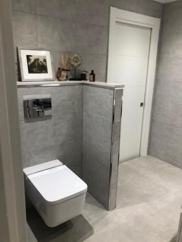 a bathroom with a white toilet and a sink at Piso en el emblemático barrio antiguo de Oviedo in Oviedo