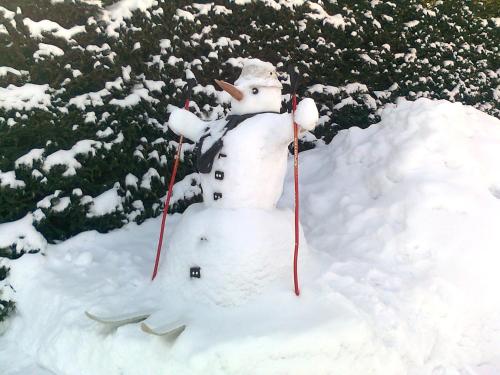 a snowman is standing in a pile of snow at Apartmán v Srní in Srní