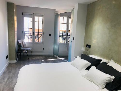 1 dormitorio con 1 cama blanca grande con almohadas blancas en Piso en el emblemático barrio antiguo de Oviedo, en Oviedo