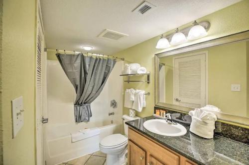 a bathroom with a sink and a toilet and a mirror at Bayview Resort Penthouse w/ Sunset Views in Myrtle Beach