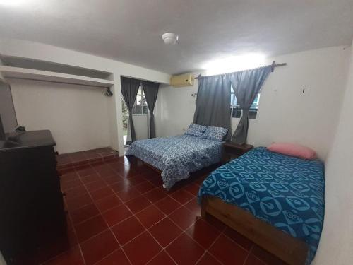1 dormitorio con 2 camas y TV. en Beicoc2 en Cozumel