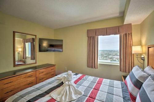 ein Schlafzimmer mit einem Bett mit einer Kommode und einem Fenster in der Unterkunft Bayview Resort Penthouse w/ Sunset Views in Myrtle Beach