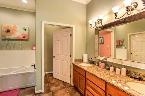 La salle de bains est pourvue de 2 lavabos, d'une baignoire et d'un miroir. dans l'établissement Texas Vacation Rental with Fireplace, Near Lakes, à Marshall