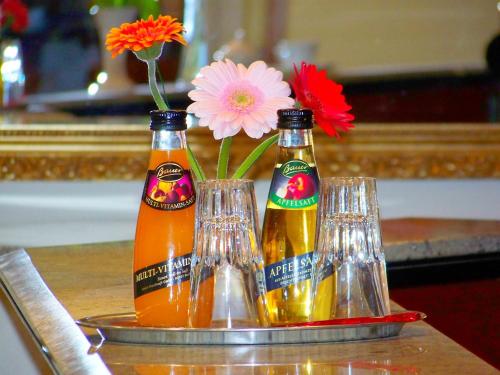 two bottles of beer and a vase with flowers at Hotel Amadeus ROYAL Berlin in Berlin
