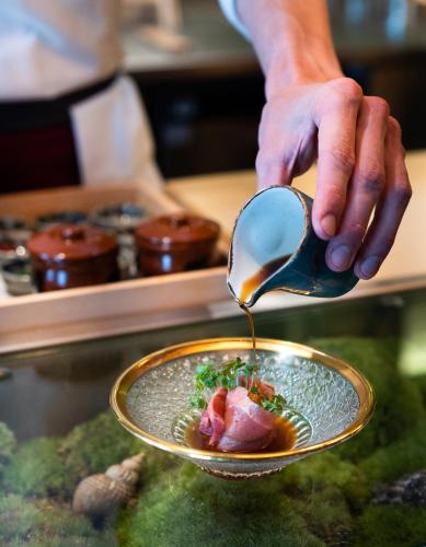 a person pouring food into a bowl with a spoon at Beaverbrook Town House in London