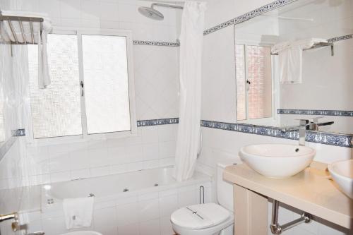 a white bathroom with a sink and a toilet at Villa María Elena, en Fuente del Gallo in Conil de la Frontera