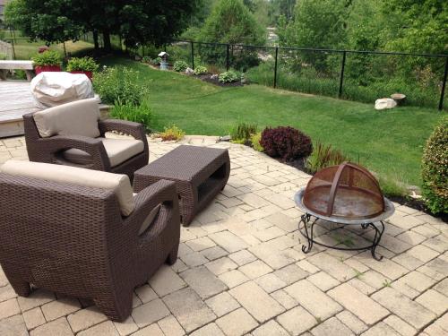 a patio with wicker chairs and a table and a lawn at Cozy Luxury on the Thames in Ontario! in London