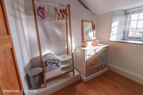 ein Ankleidezimmer mit einem Spiegel und einer Kommode in der Unterkunft UpAlong Cottage - HiddenDevon in Winkleigh