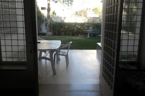 una mesa y sillas en una habitación con patio en Villa meublée à skanes Monastir en Monastir
