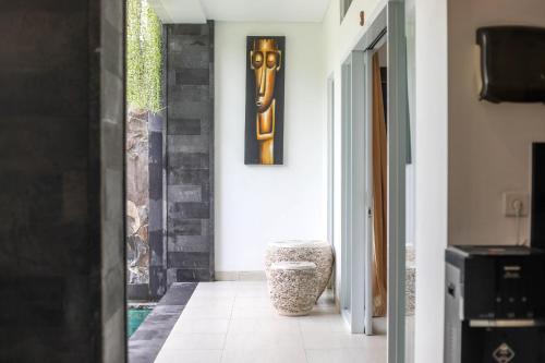 a hallway with a door to a room with a picture on the wall at Puri Bagus Villa by Great Bali Villas in Legian