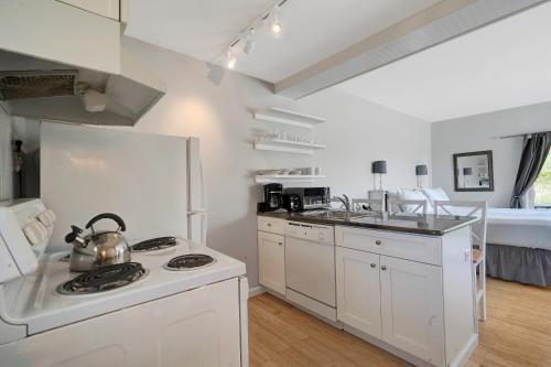 a white kitchen with a tea kettle on a stove at Windward Shores in Amagansett