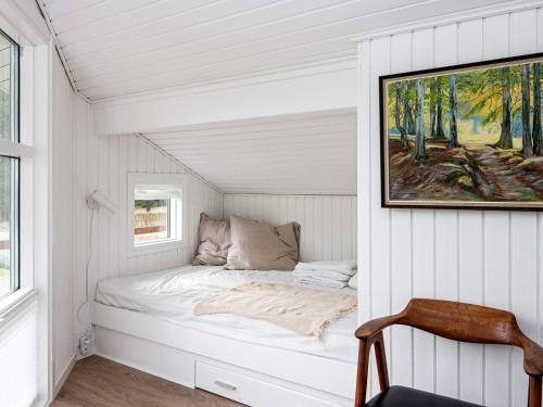 a bed in a small room with a painting on the wall at Holiday home Silkeborg XXI in Silkeborg