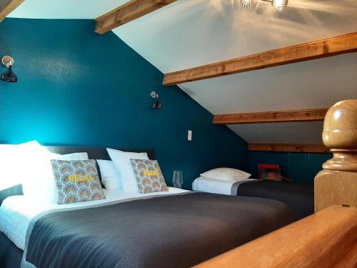 two beds in a room with blue walls at Gite climatisé L'Orée des Landes Proche Center Parcs in Pindères