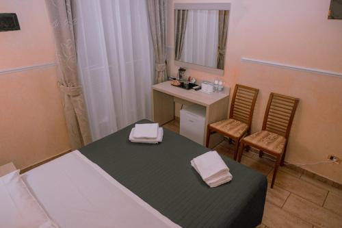 a bedroom with a bed and a desk and a mirror at Hotel Aristotele in Rome