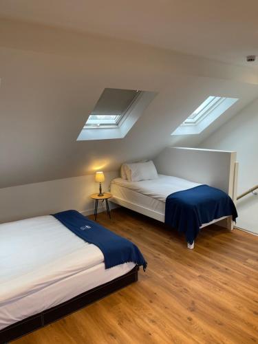 two beds in a room with two windows at Cambridge Studios and Suites by Tas Accommodations in Cambridge