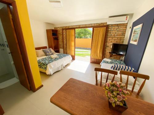 a bedroom with a bed and a dining room with a table at Pousada Portal Sul in Florianópolis