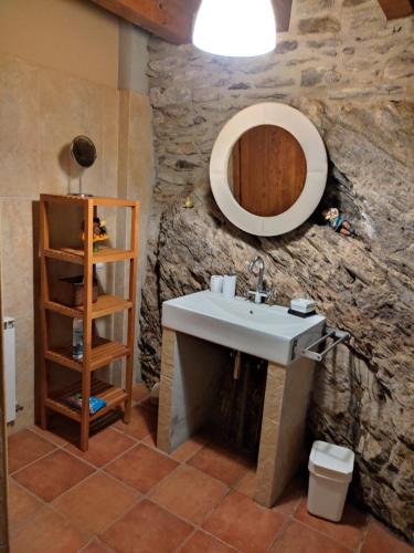 a bathroom with a sink and a stone wall at Cobert de Martí in Bayasca