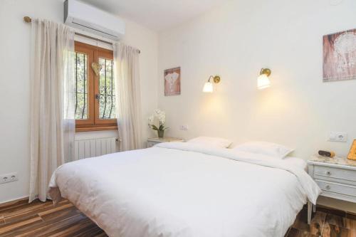 Villa Encinas في كومبري ديل سول: غرفة نوم بيضاء مع سرير كبير ونافذة