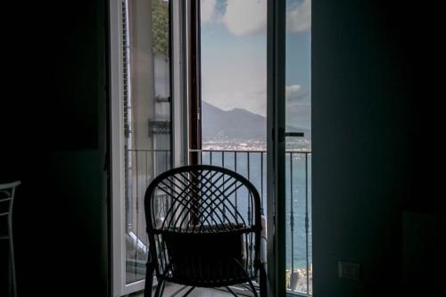 a chair sitting in front of a window at Camerelle Apartments - casa vacanze in Castellammare di Stabia