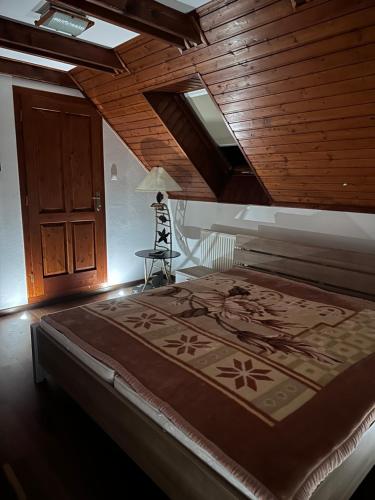 a bedroom with a large bed with a wooden ceiling at Village Light House in Omšenie