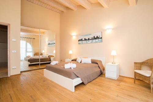 - une chambre avec un lit, une chaise et un miroir dans l'établissement Villa Falco, à Trequanda