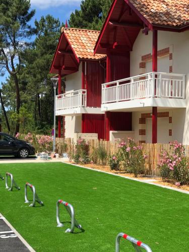 ein Haus mit einem Garten voller grünem Gras mit Bentleys in der Unterkunft Azurea - Charmant appartement à Andernos-les-Bains in Andernos-les-Bains